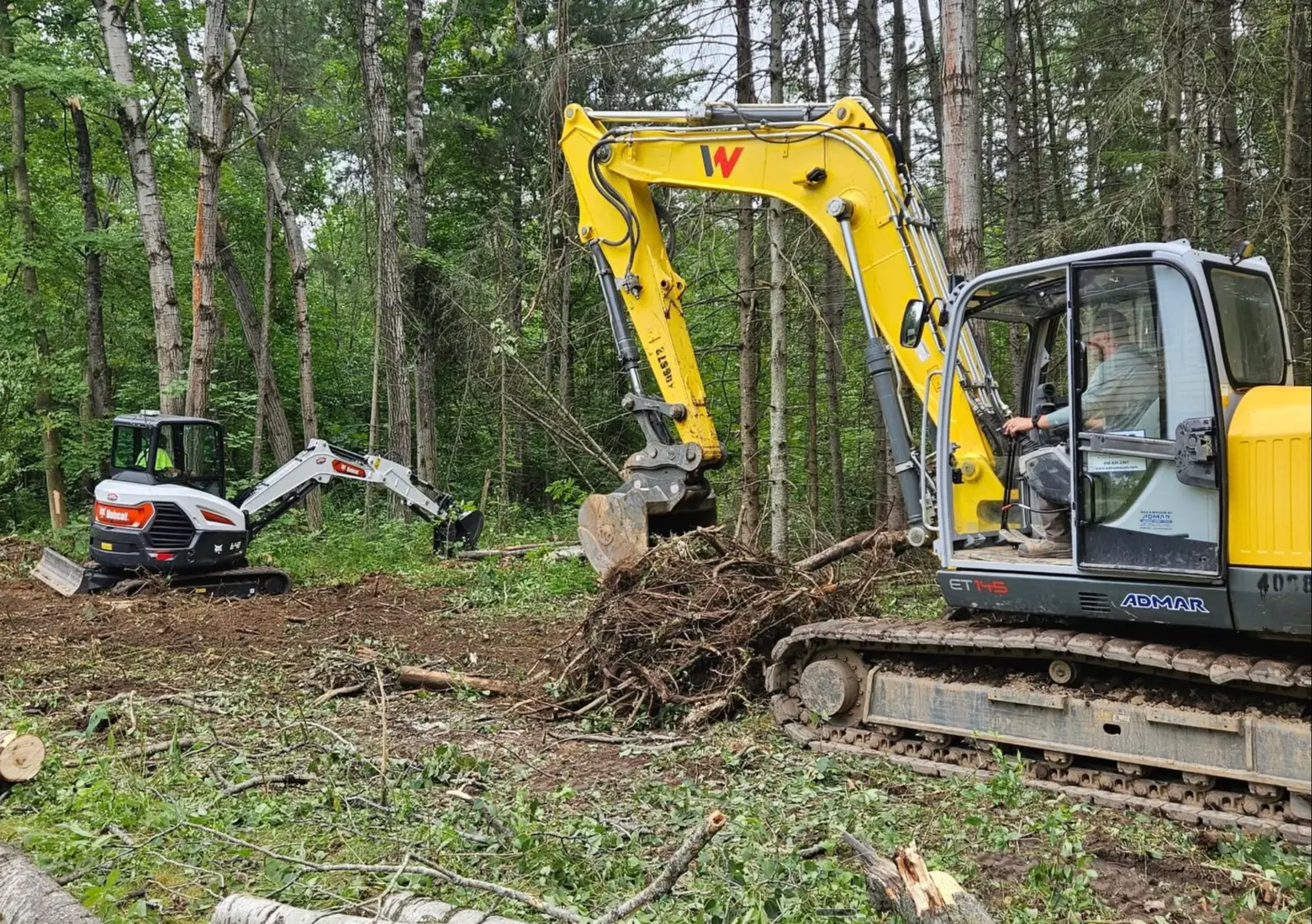 CB OnSite excavators clearing a wooded residential property
