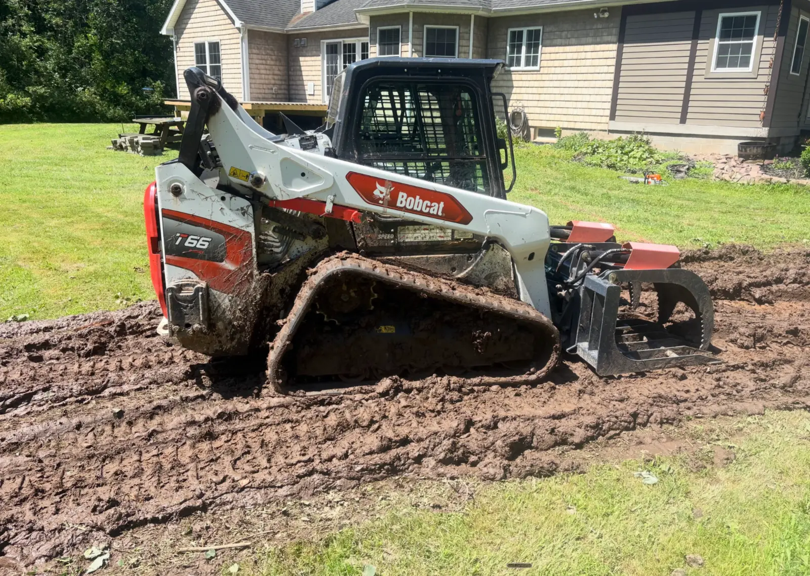 CB OnSite Bobcat track loader working in a residential yard