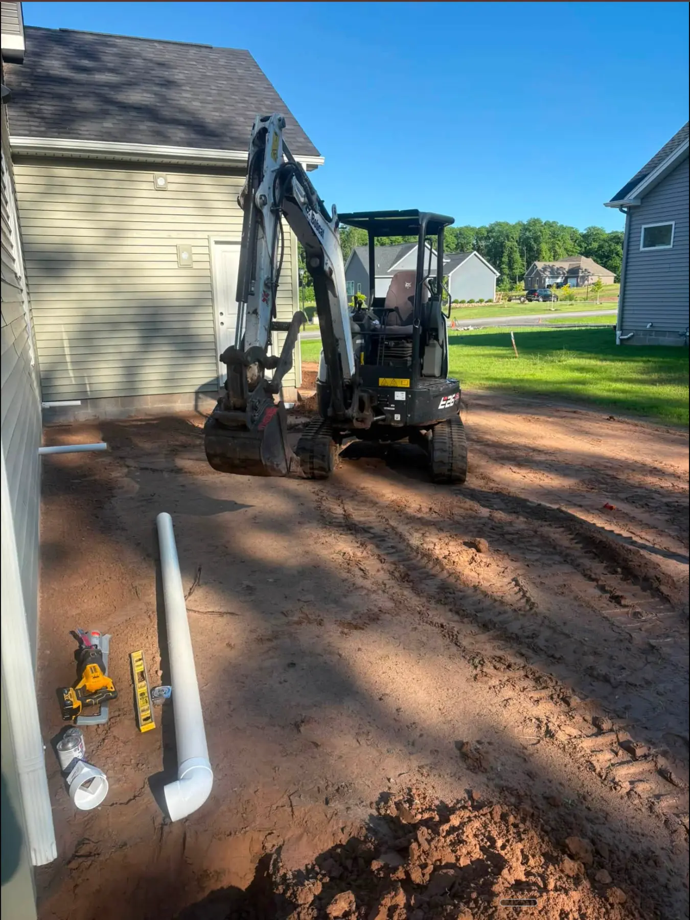 CB OnSite compact excavator working between residential homes